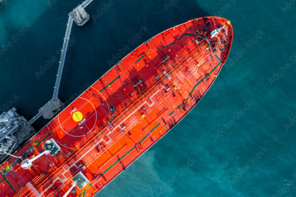 Aerial view oil ship tanker vessel loading and unloading in oil terminal station refinery, Global business import export logistic transport sea freight cargo tanker, Red crude oil tanker ship at port.