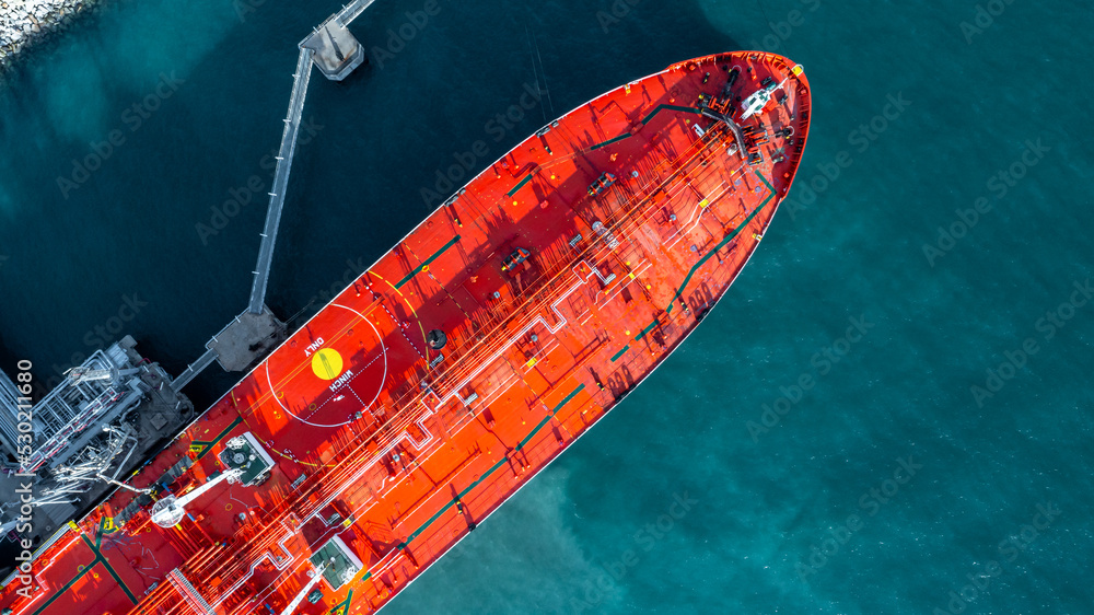 Aerial view oil ship tanker vessel loading and unloading in oil terminal station refinery, Global business import export logistic transport sea freight cargo tanker, Red crude oil tanker ship at port.