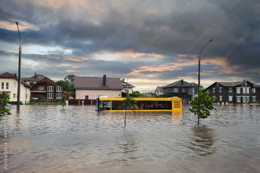 Extreme heavy rain storm weather. Flooded streets of the neighborhood. A flooded road junction with a drowned house. Heavy rains from tropical storm caused many flooded areas. Rains caused many floods