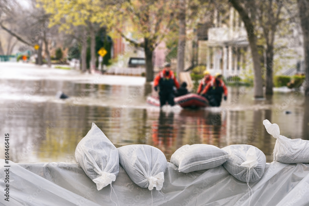 Flood Protection Sandbags with flooded homes in the background (Montage)