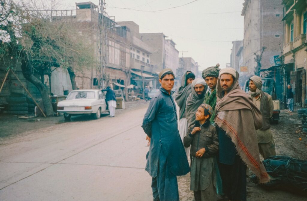 A group of people standing on the side of a road