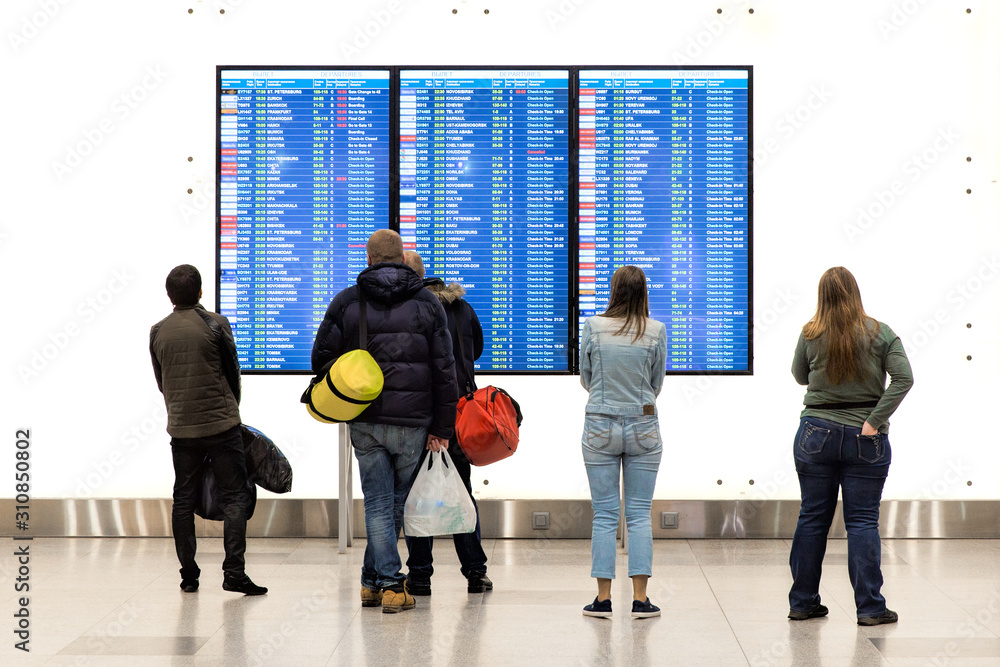 Passengers look at the departure board in Domodedovo international airport