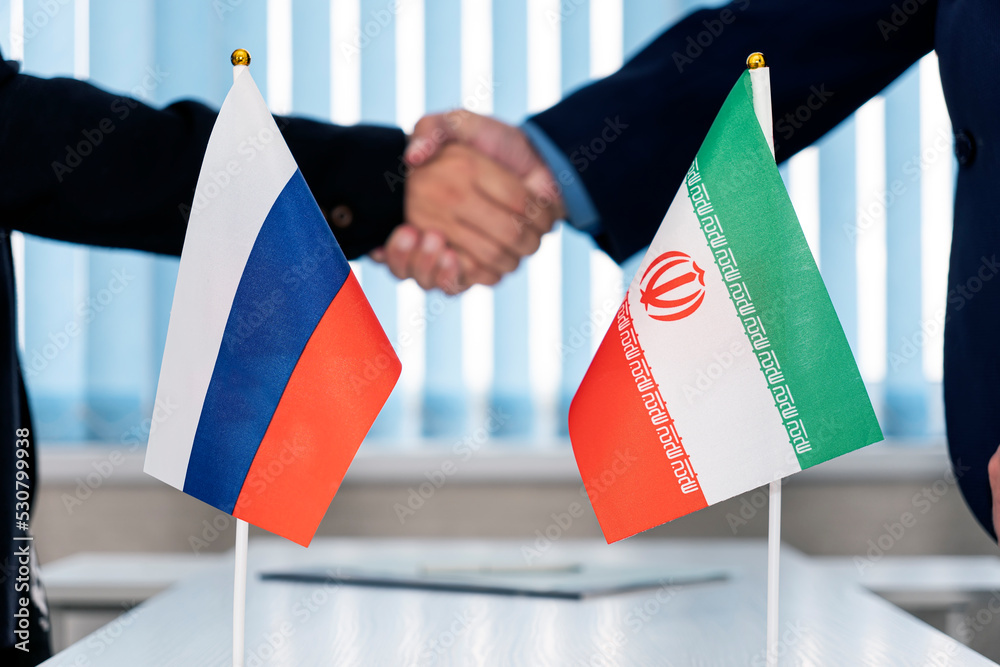 Political flags of russia and iran on table in international negotiation room. concept of negotiations, collaboration and cooperation of countries. agreement between governments.