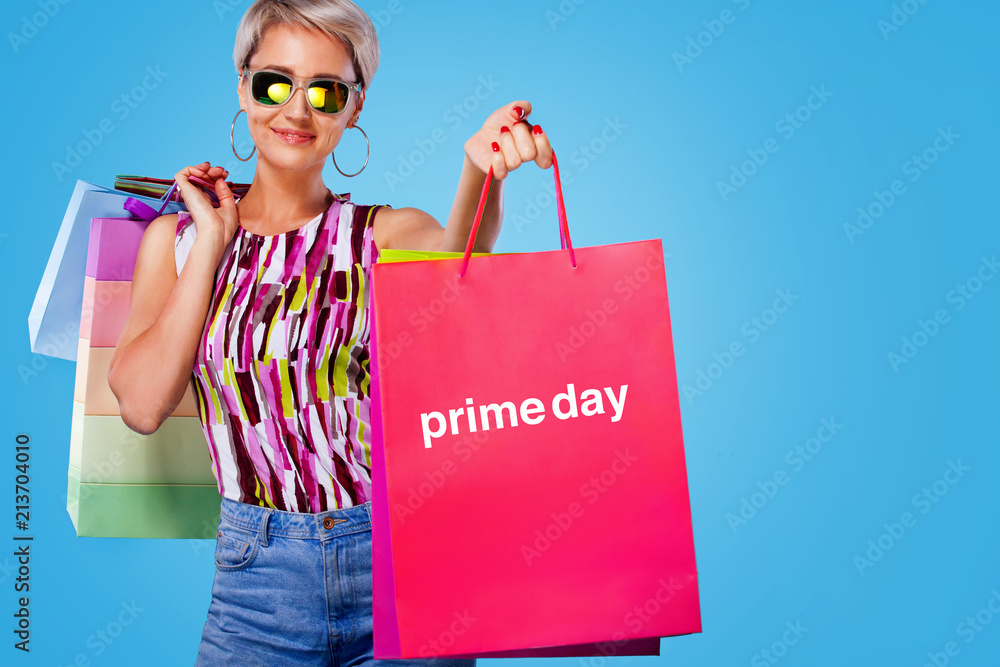 Shopping woman holding color bags isolated on blue background in black friday holiday. Summer shopping sale concept.