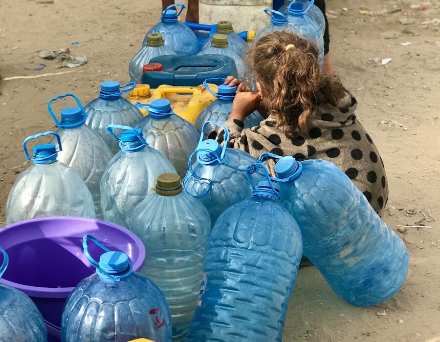 a group of people standing around a table filled with water bottles