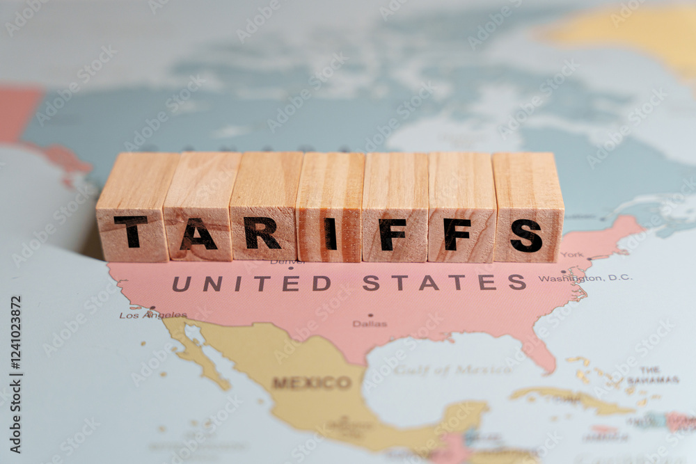 Wooden blocks spelling TARIFFS are placed on a map of North America, specifically over the United States and Mexico